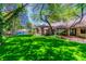 Expansive backyard featuring manicured lawn, mature trees, and covered patio, perfect for outdoor living and entertaining at 108 Quail Run Rd, Henderson, NV 89014