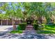 Charming home featuring mature trees, a brick walkway, and an attached three-car garage at 108 Quail Run Rd, Henderson, NV 89014