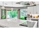 Bright kitchen featuring modern appliances, stainless steel hood, and an outdoor view at 108 Quail Run Rd, Henderson, NV 89014