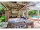 Gourmet outdoor kitchen with a stainless steel grill, stone countertop, dining area, and a view of the pool at 108 Quail Run Rd, Henderson, NV 89014