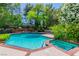 A sparkling backyard pool and spa surrounded by mature trees and lush greenery for a private retreat at 108 Quail Run Rd, Henderson, NV 89014