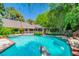 Backyard swimming pool area surrounded by lush greenery with diving board and hot tub at 108 Quail Run Rd, Henderson, NV 89014
