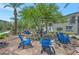 Common area showcasing blue Adirondack chairs, palm trees, and desert landscaping for relaxing outdoors with neighbors at 12348 Golden Wreath Rd # 1, Las Vegas, NV 89183