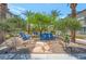 Community common area features blue Adirondack chairs, palm trees, decorative stone, and various shrubs for resident enjoyment at 12348 Golden Wreath Rd # 1, Las Vegas, NV 89183