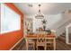 Cozy dining room featuring an orange accent wall, rustic decor, and a stylish chandelier at 12348 Golden Wreath Rd # 1, Las Vegas, NV 89183