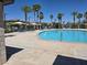 Community pool area with lounge chairs, sun umbrellas, and nearby palm trees for relaxing outdoor living at 12348 Golden Wreath Rd # 1, Las Vegas, NV 89183