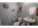 Charming powder room with a pedestal sink, tasteful decor, and soft blue walls at 12348 Golden Wreath Rd # 1, Las Vegas, NV 89183