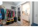 Organized walk-in closet leading into a bathroom with double vanity and a large mirror at 12348 Golden Wreath Rd # 1, Las Vegas, NV 89183