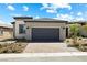 Well-maintained single-story home with a gray garage door and desert landscaping at 171 Palm Fox Ct, Henderson, NV 89011