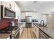 Modern kitchen features stainless steel appliances, gray counters, a large center island, and wood-look floors at 171 Palm Fox Ct, Henderson, NV 89011
