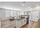 Kitchen island featuring stainless steel dishwasher and sink with seating and an open layout to dining and living rooms at 171 Palm Fox Ct, Henderson, NV 89011