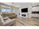 Living room featuring a large sectional sofa, electric fireplace, and access to the kitchen at 171 Palm Fox Ct, Henderson, NV 89011