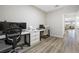 Home office with two desks, wood flooring, and views into the living room and outside at 171 Palm Fox Ct, Henderson, NV 89011