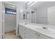 Well-lit bathroom with a double vanity, tiled floor, and tub-shower combination at 180 Duck Hollow Ave, Las Vegas, NV 89148