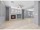 Spacious living room boasts tile floors, natural light, a modern fireplace, and a ceiling fan at 180 Duck Hollow Ave, Las Vegas, NV 89148