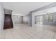 Open living area showcasing a staircase, dining space, neutral walls, tile flooring, and backyard access at 180 Duck Hollow Ave, Las Vegas, NV 89148