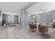 Open-concept living space features tile floors, modern furnishings, and seamless flow between living, dining, and kitchen areas at 180 Duck Hollow Ave, Las Vegas, NV 89148