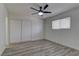 A simple bedroom with light colored walls, a ceiling fan, and wood laminate flooring at 1901 Farnam Pl, Las Vegas, NV 89102
