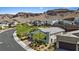 Scenic aerial view of a modern home with mountain views, surrounded by landscaped greenery in a desert community at 1957 Regal Bluff Dr, Henderson, NV 89052