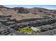 Aerial view of a desert community, featuring homes with desert landscaping and a majestic mountain backdrop at 1957 Regal Bluff Dr, Henderson, NV 89052