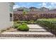 Well-maintained backyard with an attractive rock wall and a decorative paver walkway among desert landscaping at 1957 Regal Bluff Dr, Henderson, NV 89052