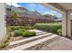 Covered patio offering a view of the decorative rock wall, desert landscaping, and stylish paver walkway at 1957 Regal Bluff Dr, Henderson, NV 89052