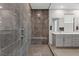 Modern bathroom with glass shower, gray tiling, and spacious double vanity at 1957 Regal Bluff Dr, Henderson, NV 89052