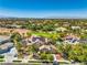 A sunny aerial view shows the house with solar panels, lush landscaping, a pool, and city views at 2086 Troon Dr, Henderson, NV 89074