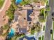 This bird's-eye shows solar panels, the pool, outdoor living area, driveway, and lush backyard landscaping at 2086 Troon Dr, Henderson, NV 89074