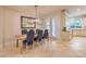Light-filled dining room includes French doors, travertine tile floors, and modern chandelier at 2086 Troon Dr, Henderson, NV 89074