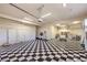 Spacious garage with black and white checkered flooring, white storage cabinets, and bright overhead lighting at 2086 Troon Dr, Henderson, NV 89074