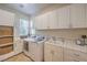 This bright laundry room features ample counter space, lots of storage, and a washer and dryer at 2086 Troon Dr, Henderson, NV 89074