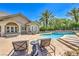 Beautiful backyard pool with a spa, lounge chairs, and lush landscaping creating a private oasis at 2086 Troon Dr, Henderson, NV 89074