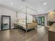 Luxury bedroom features a stone fireplace, a four-poster bed, and sliding glass door to outside at 2104 Plaza De La Candela, Las Vegas, NV 89102
