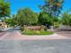 Community entrance sign displaying 'Spanish Oaks' set amidst well-maintained landscaping and brick-paved roundabout at 2104 Plaza De La Candela, Las Vegas, NV 89102