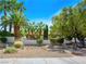 Manicured front yard showcases lush landscaping and mature palm trees, creating great curb appeal at 2104 Plaza De La Candela, Las Vegas, NV 89102