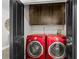Well-organized laundry room with red front-load washer and dryer at 2104 Plaza De La Candela, Las Vegas, NV 89102
