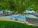 A view of outdoor tennis courts with multiple courts surrounded by trees, landscaping, and well-maintained grass at 2104 Plaza De La Candela, Las Vegas, NV 89102