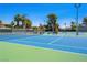 Well-maintained blue and green outdoor tennis courts are ready for play with landscaping and lights at 2104 Plaza De La Candela, Las Vegas, NV 89102