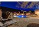 Outdoor lounge area with a luxurious pool, spa, waterfall, and built-in outdoor kitchen at 2124 Pont National Dr, Henderson, NV 89044
