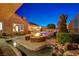 An outdoor firepit and a tranquil water feature, with beautiful landscaping all around at 2124 Pont National Dr, Henderson, NV 89044