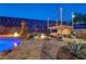 Luxe backyard offers a cozy fire pit, outdoor kitchen, and gorgeous pool and spa at 2124 Pont National Dr, Henderson, NV 89044