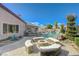 Private backyard with a pool, fire pit, mature landscaping, and a covered patio at 2124 Pont National Dr, Henderson, NV 89044