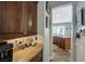 Hallway with coffee bar, granite counters, custom cabinets, and view to the kitchen sink and window at 2124 Pont National Dr, Henderson, NV 89044