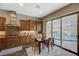 Gourmet kitchen with custom cabinets, granite counters, stainless appliances, and sliding glass doors to the pool and patio at 2124 Pont National Dr, Henderson, NV 89044