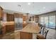 Gourmet kitchen with a center island, stainless steel appliances, granite countertops, and a view of the backyard pool at 2124 Pont National Dr, Henderson, NV 89044