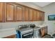 Convenient laundry room featuring custom cabinets, sink, granite counters, washer, and dryer at 2124 Pont National Dr, Henderson, NV 89044