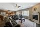 Open-concept living room with a fireplace, tile floors, and seamless connection to the kitchen and backyard pool at 2124 Pont National Dr, Henderson, NV 89044