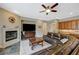 Cozy living room with fireplace, dark wood floors, modern lighting, and access to the kitchen at 2124 Pont National Dr, Henderson, NV 89044