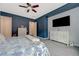 Nicely decorated bedroom offers large window, ceiling fan, guitar, and modern furniture at 2124 Pont National Dr, Henderson, NV 89044